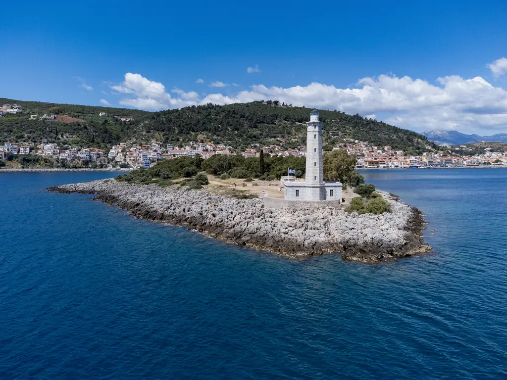 The white lighthouse at the tip of Kranai, Gythio behind it across the strait
